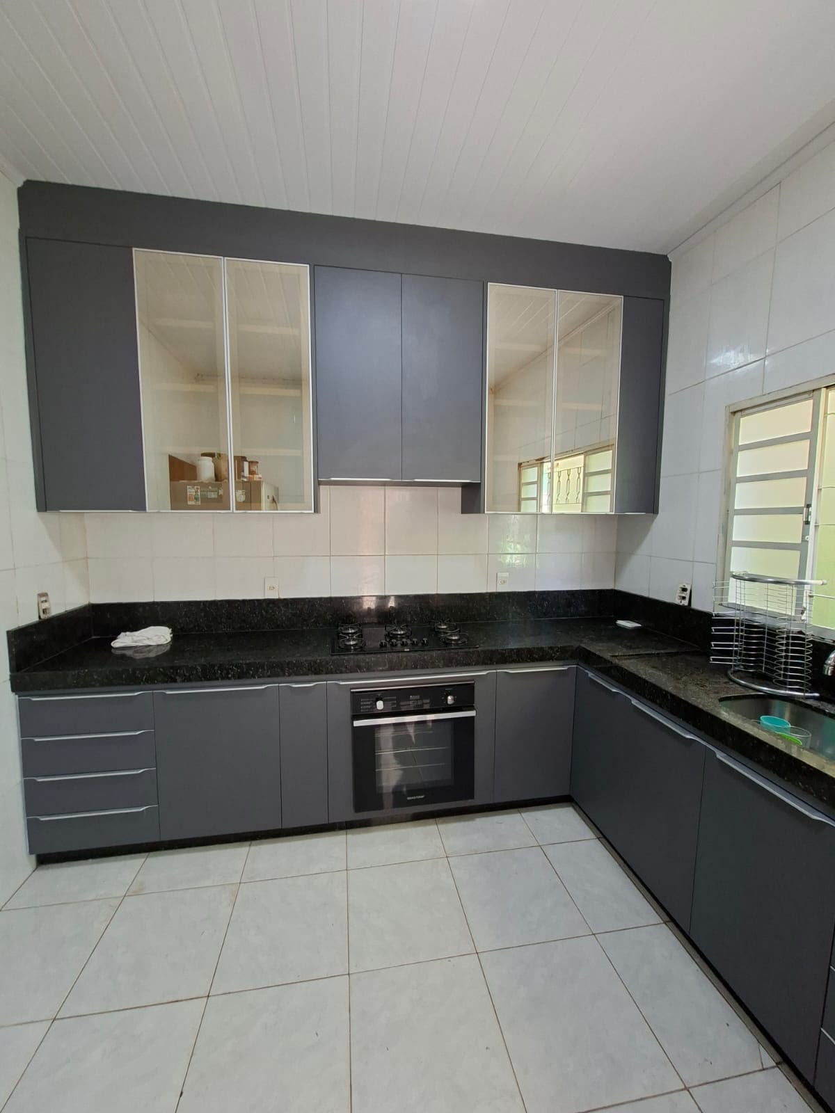 Cozinha planejada cinza com bancada preta